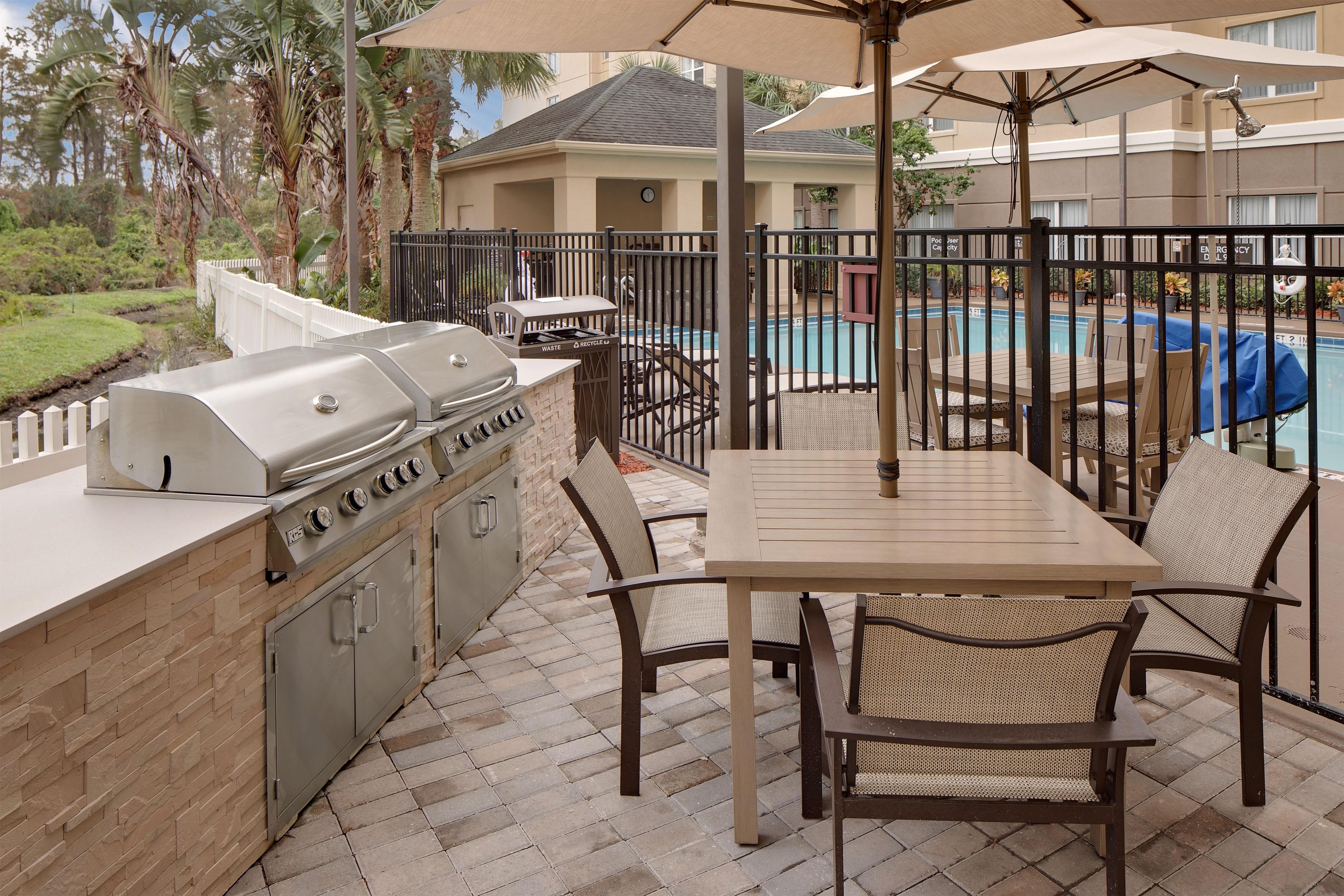 Une terrasse extérieure équipée d’un barbecue, d’un coin salon et d’une piscine.
