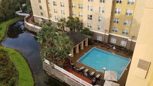 A hotel with a swimming pool, a white fence, and a water feature. - Homewood Suites by Hilton Orlando-Maitland (Maitland)