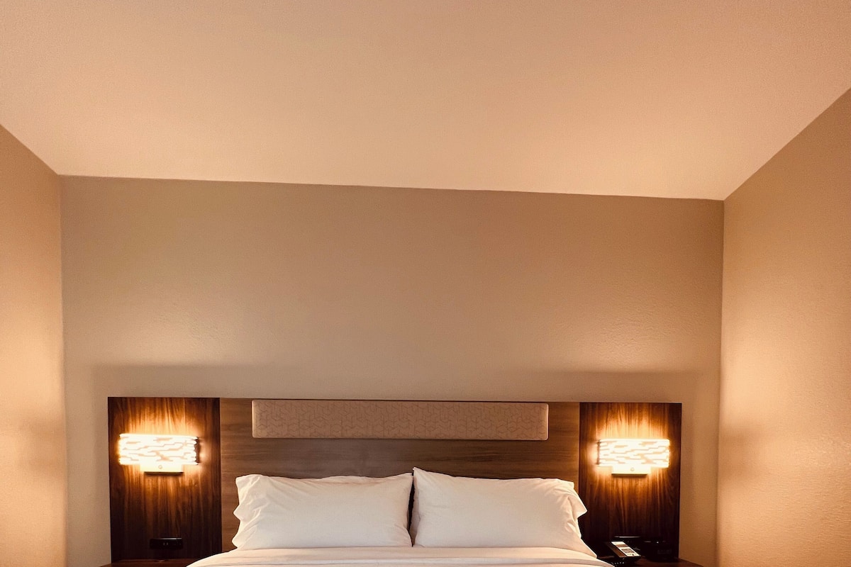 Suite, 1 cama de matrimonio grande, bañera accesible (Mobility) | 1 dormitorio, caja fuerte, escritorio y cortinas opacas
