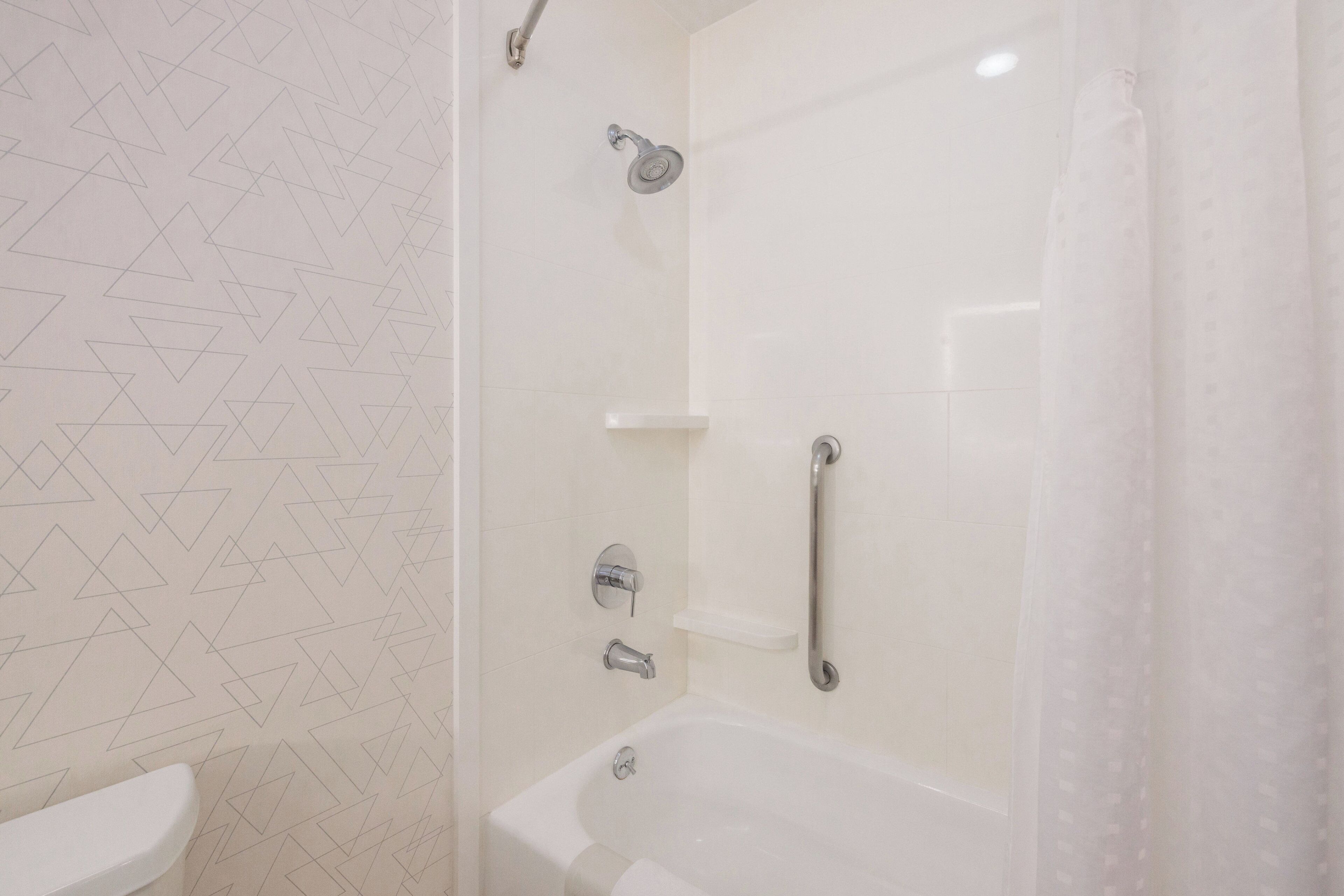 A bathroom with a shower, toilet, and a bathtub.