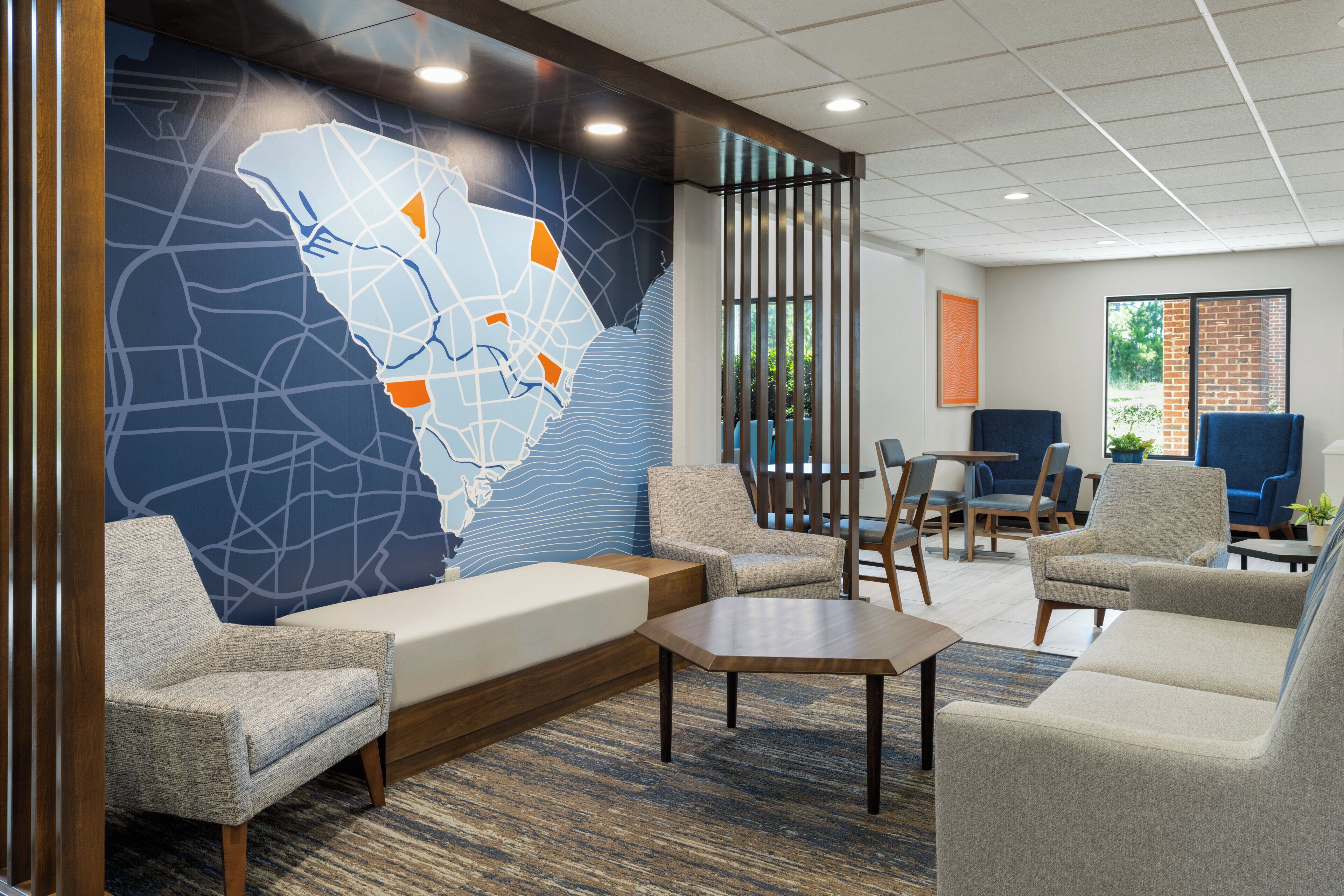A modern lobby with a large map mural, comfortable seating, and a view of the outdoors.