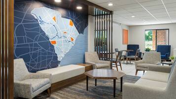 A modern lobby with a large map mural, comfortable seating, and a view of the outdoors.
