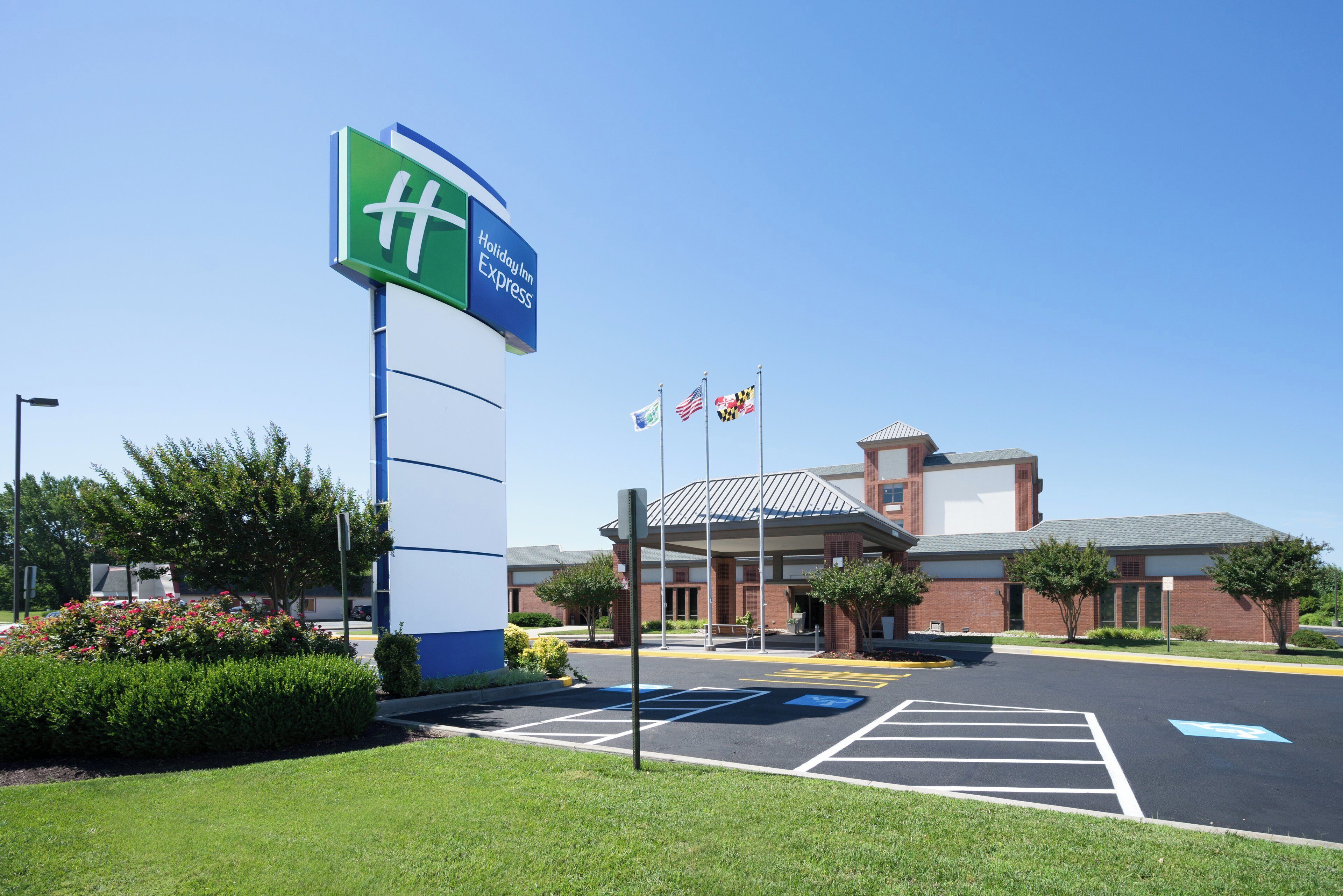 Skilt fra Holiday Inn Express, en parkeringsplads og en bygning med et overdækket indgangsparti.
