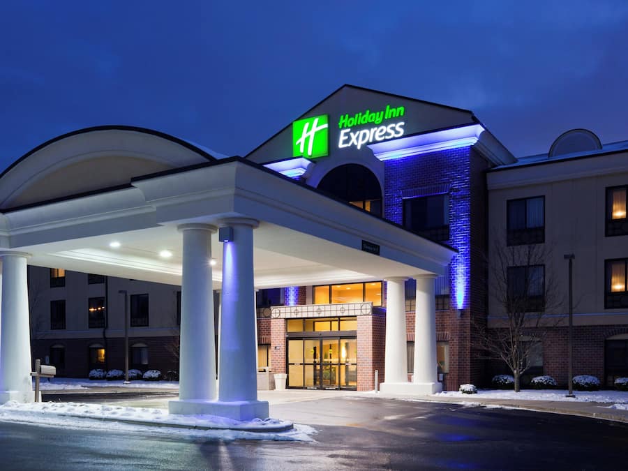Et Holiday Inn Express hotel med overdækket indgang, søjler og en murstensfacade.