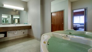 A bathroom with a large mirror, a sink with a countertop, and a bathtub with green water. - Holiday Inn Express Milwaukee North Brown Deer/Mequon by IHG (Milwaukee)