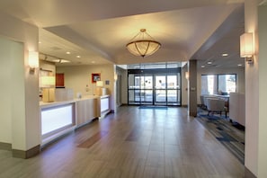 A hotel lobby with a reception desk, a chandelier, and a view of the outside through the glass doors. - Holiday Inn Express Milwaukee North Brown Deer/Mequon by IHG (Milwaukee)