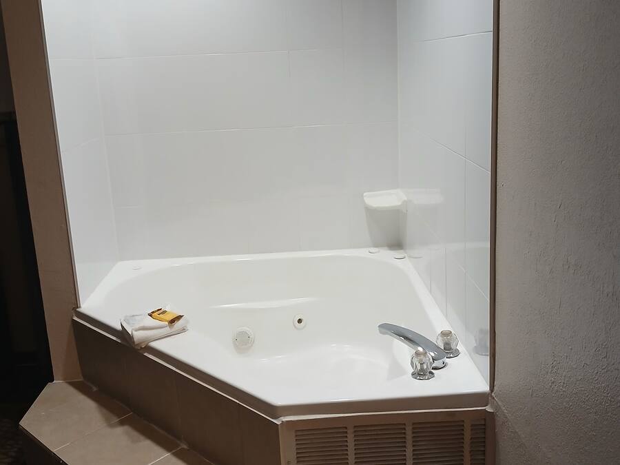 A modern bathroom with a freestanding bathtub, a towel rack, and a toilet.