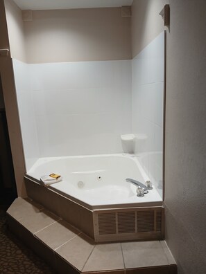 Un baño moderno con una bañera independiente, un perchero para toallas y un inodoro.