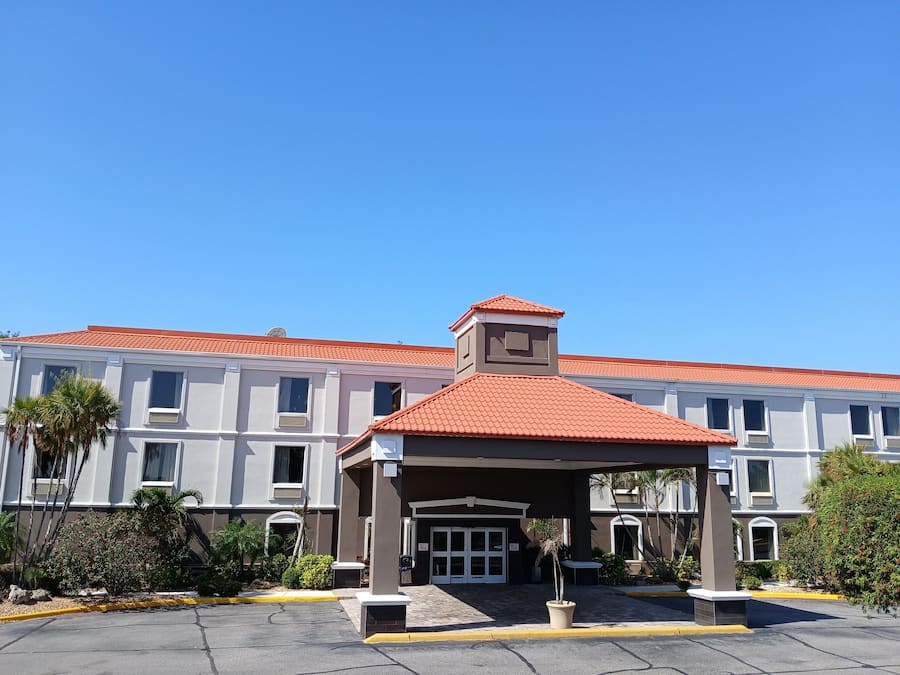 A hotel with a red-tiled roof, a covered entrance, and a symmetrical facade with multiple windows.