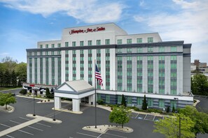 A large, modern hotel with a prominent American flag, a covered entrance, and a parking lot. - Hampton Inn & Suites Chicago-North Shore/Skokie (Skokie)