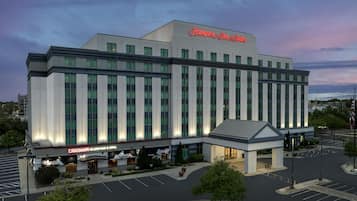 A large hotel with a prominent Hampton Inn & Suites sign, a Caribana Island Bar & Grill, and a parking lot.