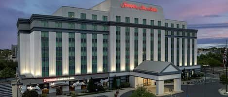 Un grand hôtel, reconnaissable à son grand panneau « Hampton Inn & Suites », qui comprend également un bar-restaurant appelé « Caribana Island Bar & Grill » et un parking.