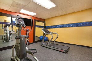 A gym with cardio equipment, a treadmill, and exercise balls.