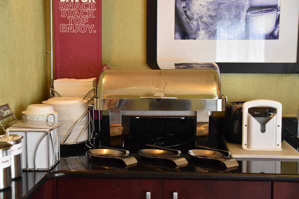 A buffet setup with a self-service station, including a variety of food containers and utensils.