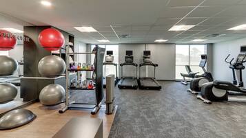 A gym with exercise equipment, treadmills, and a weightlifting area.