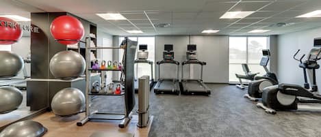 A gym with exercise equipment, treadmills, and a weightlifting area.