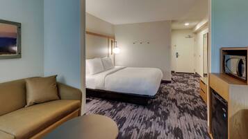 Una habitación de hotel con cama, sofá, escritorio y microondas.