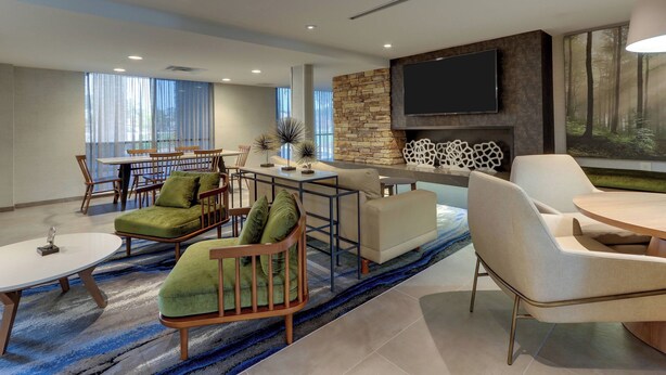 A modern living room with a fireplace, a flat-screen TV, and a dining area with a table and chairs.