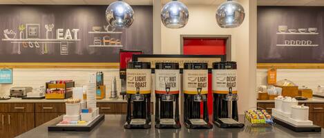 Ein Kaffee-Bereich mit mehreren Kaffee-Spenden, beschriftet mit 'Light Roast' und 'Decaf Roast'.