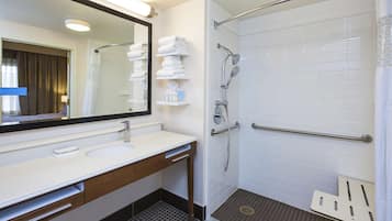 Une salle de bain moderne avec un lavabo blanc, un miroir et une douche.