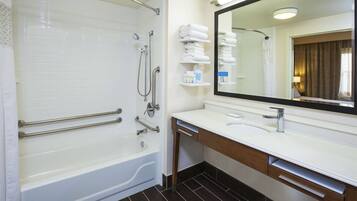 Un baño moderno con bañera, tocador con espejo y barra para toallas.