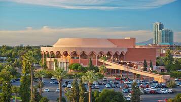 A large building with a distinctive arched entrance and a parking lot filled with cars.