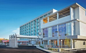 Hotel building with a flat roof and balconies offering outdoor space.