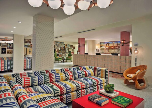 Relax in this stylish living room with a comfortable sofa, a wooden chair, and a beautiful piece of artwork.