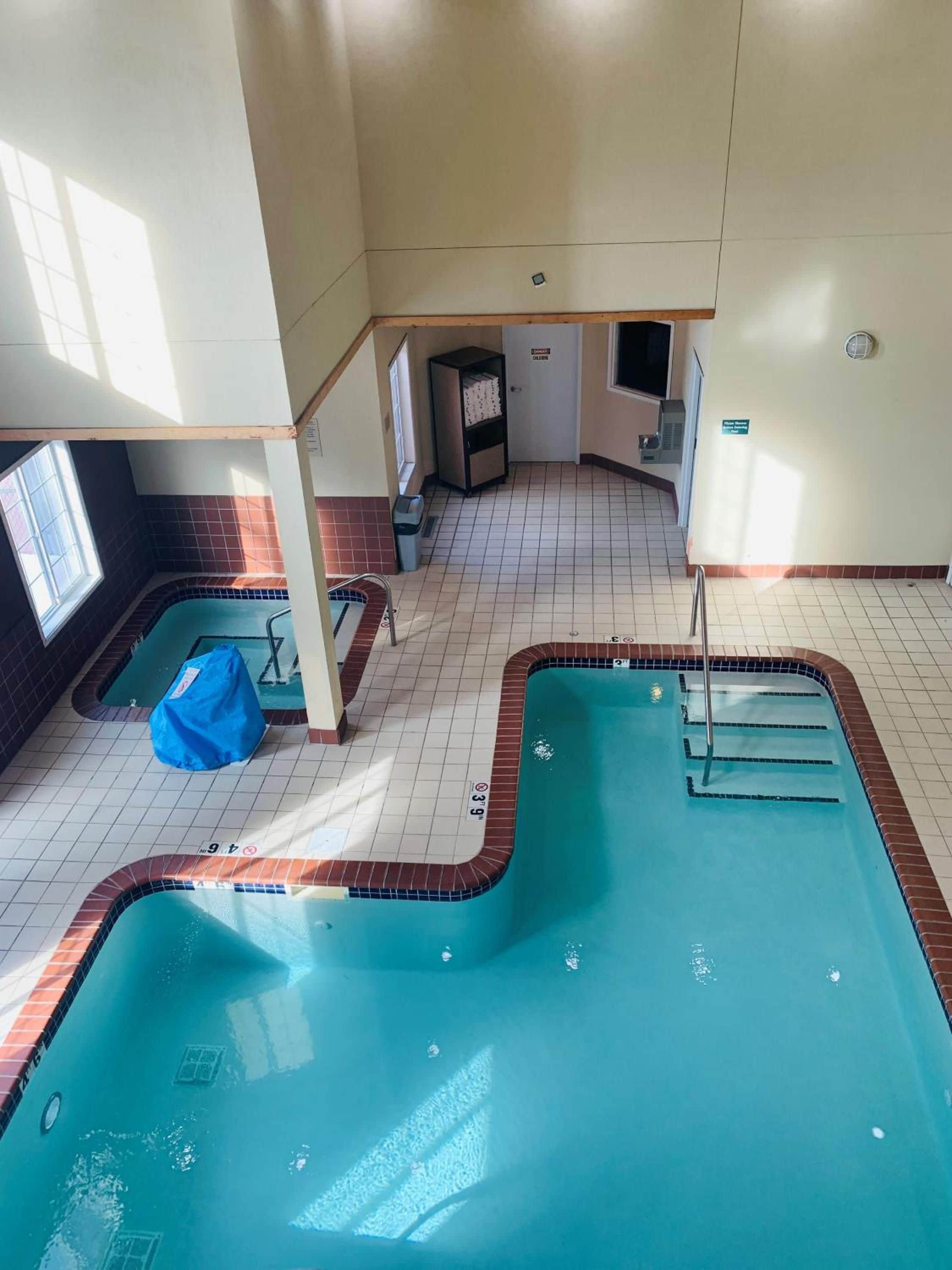 Ein Hallenbad mit mehreren Bahnen, einem Umkleideraum und einem kleinen Fenster.