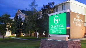 Een bordje voor GrandStay Residential Suites Hotel, met een duidelijke zichtlijn naar het gebouw op de achtergrond.