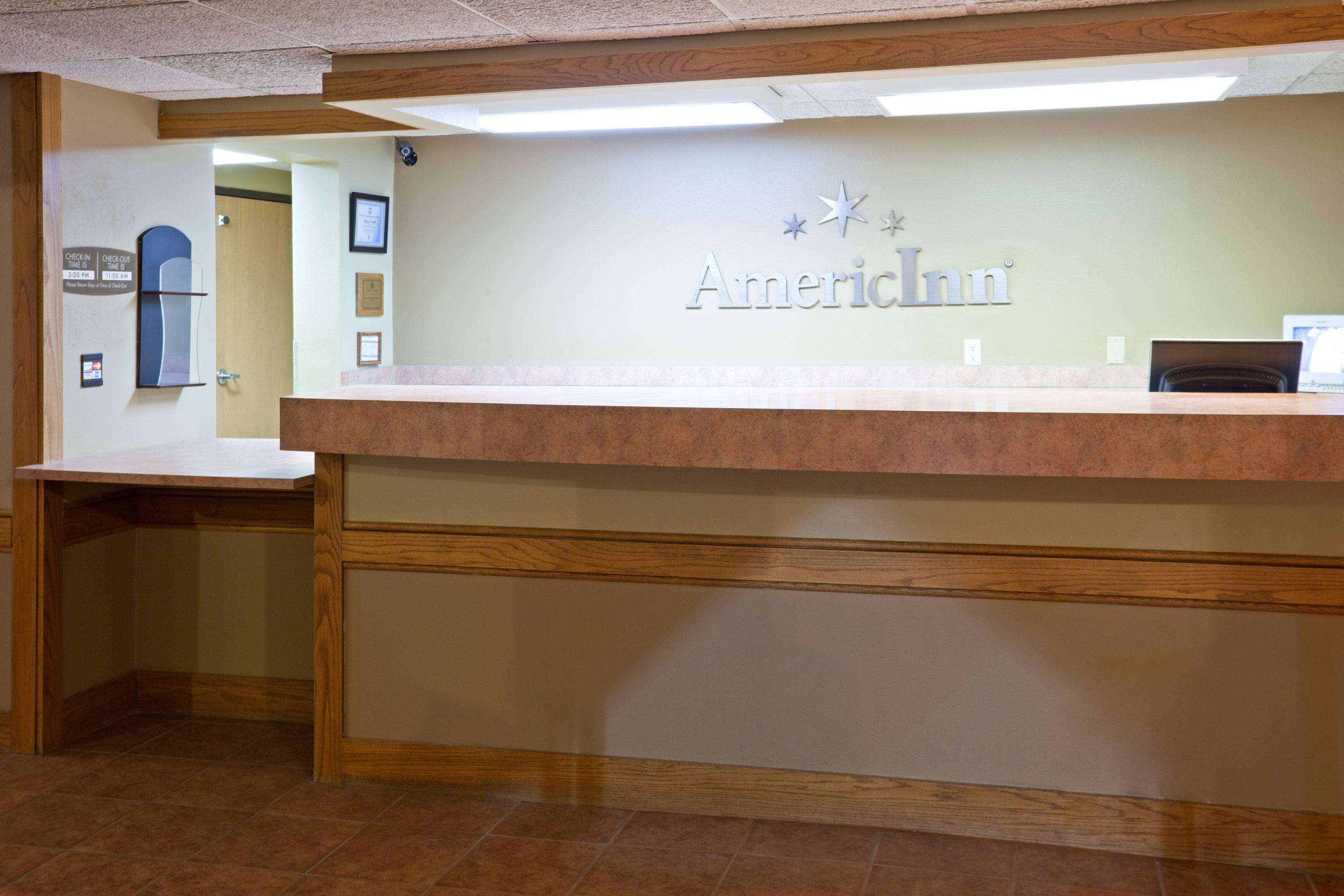 A reception desk with a sign reading "American Inn" and a computer monitor on it.