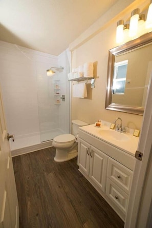 A bathroom with a shower, toilet, vanity with a mirror, and a sink. - Ocean Five Hotel & Studios (Miami Beach)