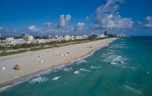 A beach with a cityscape in the background, including high-rise buildings and a clear sky. - Ocean Five Hotel & Studios (Miami Beach)