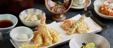 A variety of Japanese dishes including tempura, sashimi, and a bowl of miso soup.