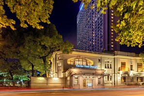 A hotel with a classic facade, a prominent entrance, and a large building in the background. - Okura Garden Hotel Shanghai (Shanghai)