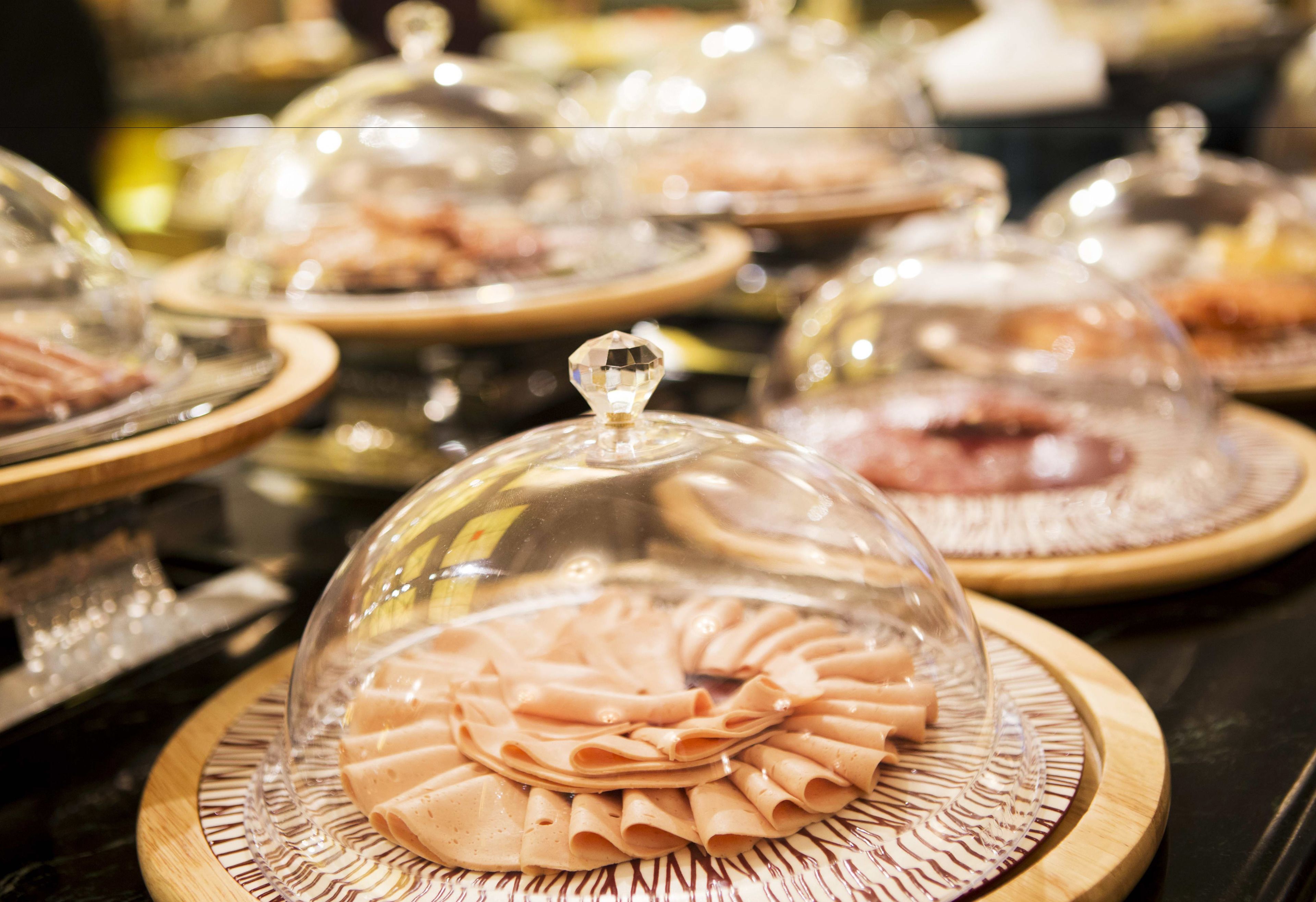 A buffet with various dishes covered in glass domes.