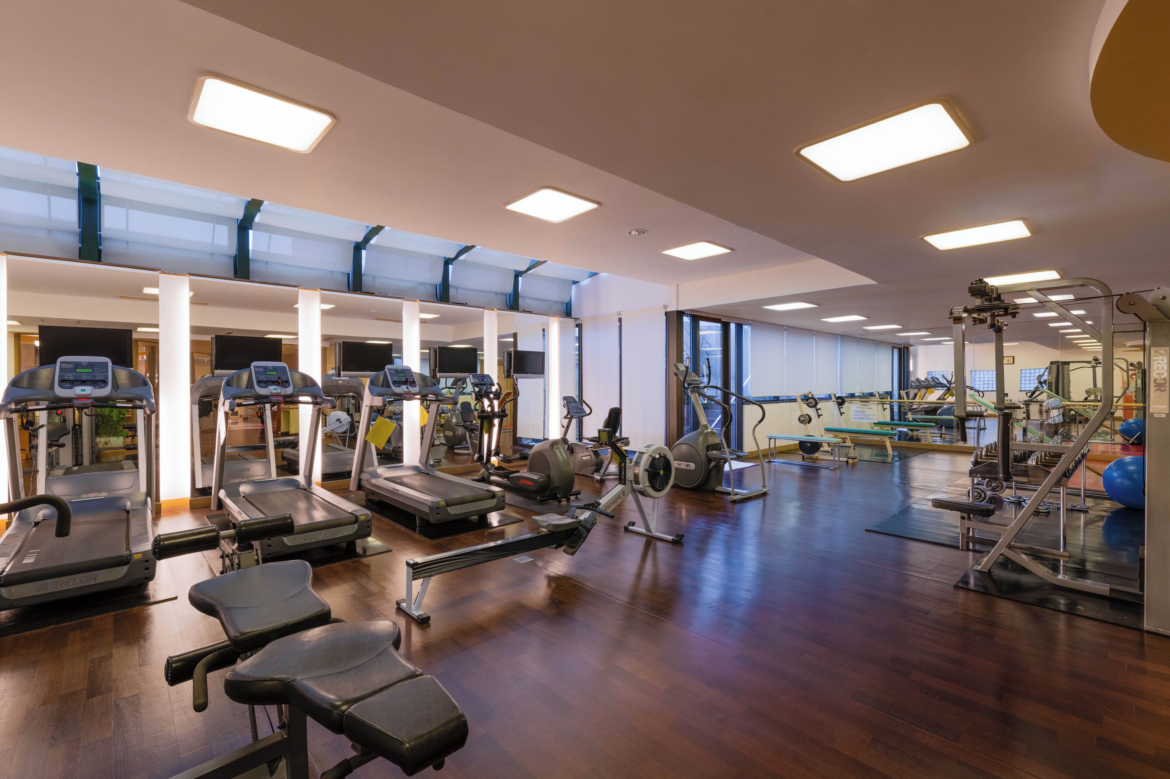 A spacious gym with treadmills, elliptical machines, and weight equipment.