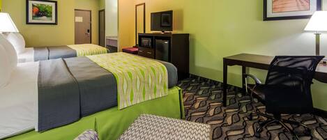 A hotel room with two beds, a desk, a chair, a TV, and a refrigerator.