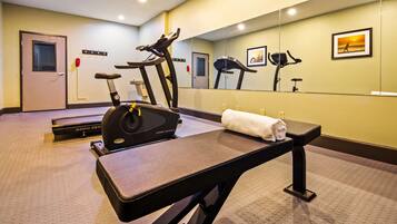 A gym with treadmills, a stationary bike, and a massage table.
