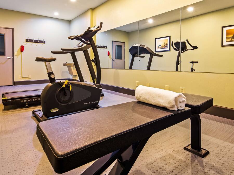 A gym with treadmills, a stationary bike, and a massage table.
