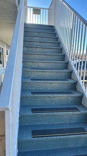 A staircase with a caution sign warning of slipperiness when wet.