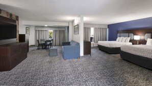 A hotel room with a large bed, a sofa, a TV, and a dining area with a table and chairs. - SureStay Plus Hotel by Best Western Gatlinburg (Gatlinburg)