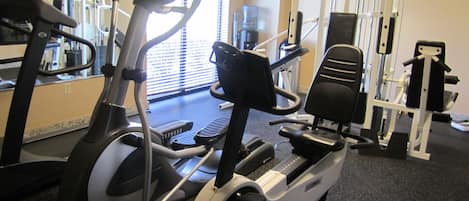 Une salle de sport intérieure équipée de matériel d’exercice, notamment des tapis de course et des appareils de musculation.