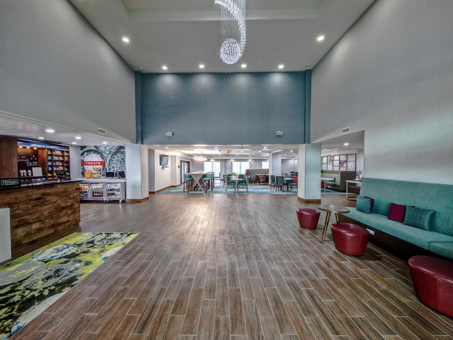 A spacious lobby with a reception desk, seating area, and a view of the dining area.
