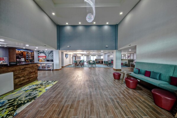 A spacious lobby with a reception desk, seating area, and a view of the dining area.