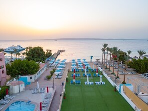 A resort with a pool, sun loungers, and umbrellas.