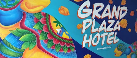A colorful mural with a tropical theme, including a large fish and the text "Grand Plaza Hotel".