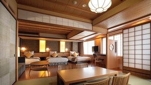 A traditional Japanese-style room with tatami flooring, a low wooden table, and futon beds.