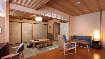 A traditional Japanese room with tatami flooring, a low table with chairs, a sofa, and sliding doors.