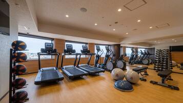 A gym with treadmills, elliptical machines, and free weights.
